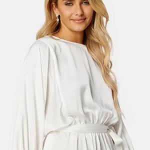 Studentklänning, Vit omlottklänning med ballongärmar - Säljer en vit kortklänning med ballongärmar och knytskärp i midjan. Klänningen har rund halsringning och är tillverkad i ett glansigt, mjukt material som ger en lyxig känsla. Perfekt för sommarens tillfällen!