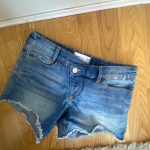 Skitsnygga blå lågmidjade jeanshorts!! - Snygga blå jeansshorts från Abercrombie kids, säljer pga ingen användning. De har små slitningar längst ner !! Fråga jätte gärna om du har några frågor!! ❣️