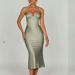 Festklänning - Ljusgrön satin långklänning med corsettdetalj - Supersnygg ljusgrön långklänning i satin med figurnära passform och corsettdetaljer upptill. Klänningen har smala axelband och markerad byst, perfekt för att sticka ut på festen.