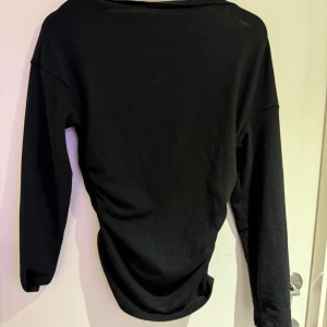 Svart långärmad - Säljer denna svarta långärmade tröjan som har lite uppsyningar på sidorna. Finns ingen kapp kvar men tror det är storlek xs/s. Använd ksk två ggr