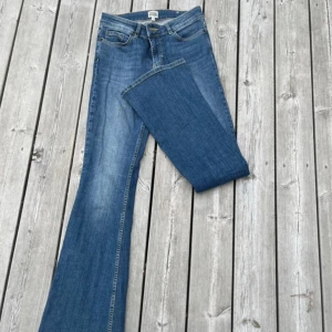 Blå bootcut jeans - Säljer ett par Lågmidjade blå bootcut jeans från twist & tango! 