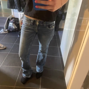 Lågmidjade bootcut jeans - Säljer ett par klassiska blå bootcut jeans med låg midja. Jeansen har fem fickor, ljus tvätt och snygga söm-detaljer. Perfekta för en avslappnad och trendig look. Strl 164 men passar xs!