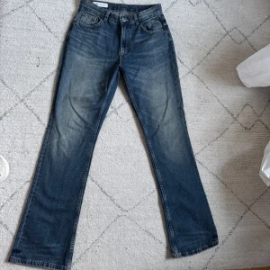 Blå bootcut jeans - Klassiska blå jeans i bootcut-modell och normal passform. Jeansen har fem fickor, knapp- och dragkedjegylf samt diskreta slitningar framtill för en avslappnad look. Lite washed denim färg. Skriv privat för fler bilder 🩷