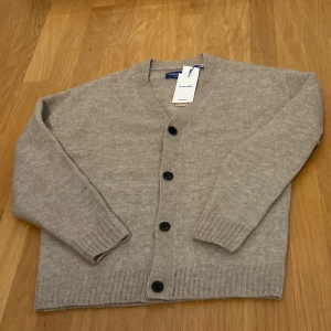 Beige kofta från Jack & Jones - Skön beige kofta från Jack & Jones med svarta knappar. Helt ny endast testad.Priset går att diskutera