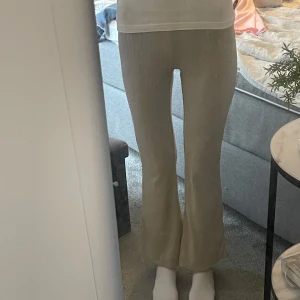 Beigea byxor från H&M - Säljer ett par beige ribbade byxor från H&M. Byxorna har hög midja och utsvängda ben. Byxorna är använda ett fårtal gånger och är lite see through. Har storlek 32 i byxor och är ca 166 cm, och byxorna är lite korta på mig💕