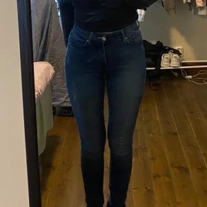 Mörkblå skinny jeans - Säljer ett par mörkblå skinny jeans med klassisk femficksdesign och silverfärgade knappar. Jeansen har en tight passform och är tillverkade i stretchigt denimtyg för en bekväm känsla. Perfekta för dig som gillar en slimmad look. (För referens är hon 162cm lång!)🌸