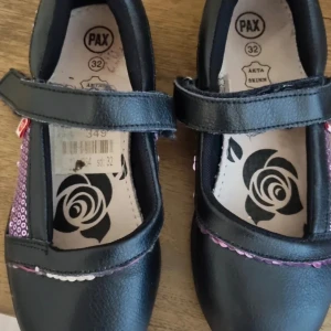 Svarta ballerinaskor från Pax med kardborreband - Säljer ett par svarta ballerinaskor från Pax i äkta skinn. Skorna har praktiskt kardborreband och dekorativt mönster i lila och vitt på sidorna. Perfekta för dig som vill ha både stil och komfort.