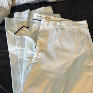 Vita chinos från GANT Hyannis Chino - Säljer ett par klassiska vita chinos från GANT, modell Hyannis Chino. Byxorna har normal passform, dragkedja och knapp framtill samt fickor bak med knapp. Perfekta för en stilren look.