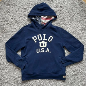 Ralph Lauren hoodie - Riktigt unik och skön Raffe Hoodie med USA mönstrad luva! | Väldigt fint skick, men liten slitning på ärmen som syns på bilden! | Storlek L (14/16)jag skulle säga att den passar en vanlig S, jag på bild är 178cm. Fråga gärna om mått! | 