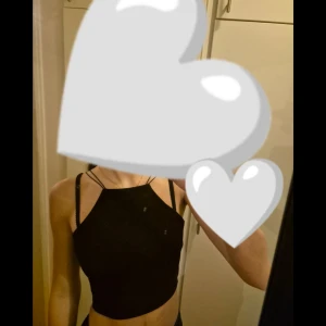 Svart croppad linnetopp med smala axelband - Säljer en svart croppad linnetopp med smala axelband och rak halsringning. Toppen är tight och passar perfekt till både jeans och kjol. Enkel och stilren design som funkar till många olika outfits.