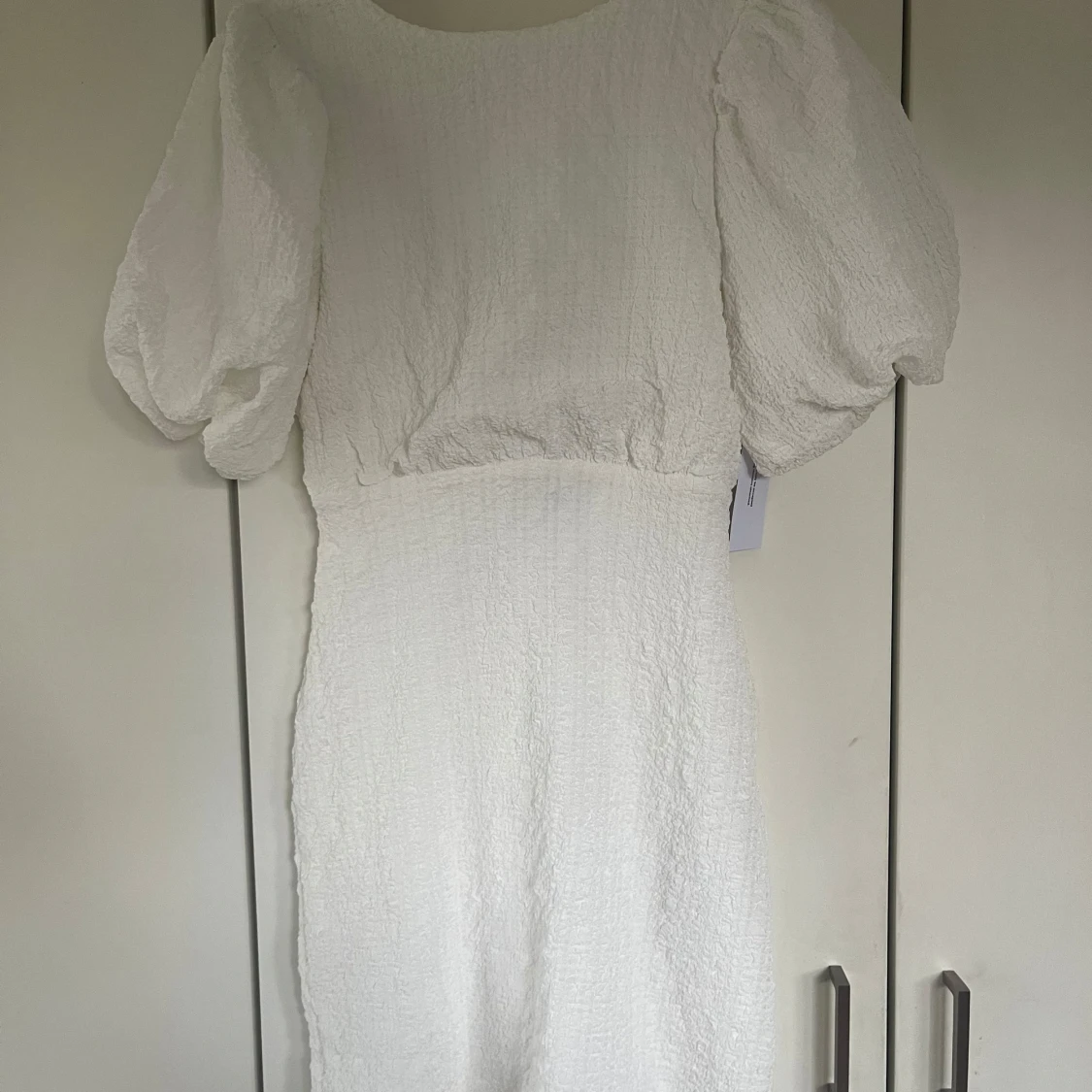 Vit klänning med puffärmar och rosettdetalj - 2