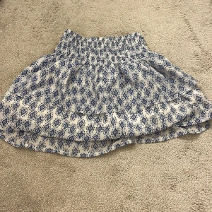 Vit och blå mönstrad kjol från H&M - Supersöt kortkjol från H&M i vitt med blått grafiskt möster. Använder inte längre. Kom privat för bilder. Pris kan diskuteras💕💕