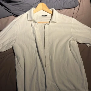 Vit kortärmad skjorta från LMTD str 164 cm - Säljer en klassisk vit skjorta från LMTD i storlek S (13-14 år). Skjortan har korta ärmar, krage och knappar framtill. Perfekt för en stilren och enkel look. Materialet känns mjukt och bekvämt.