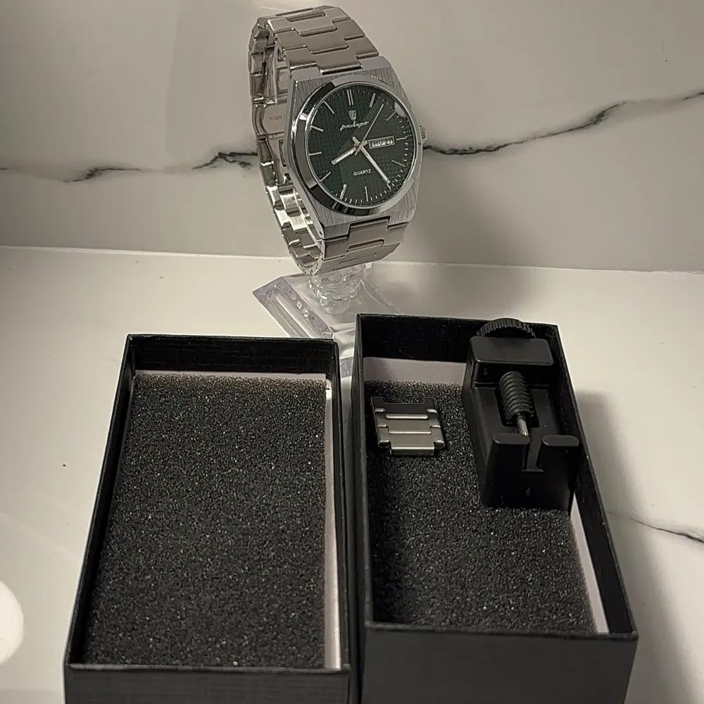 Stilren klocka med GRÖN urtavla och dag/datumvisning. Armbandet är i silverfärgat metall med viklås. Perfekt för den som gillar en klassisk look med en modern touch. BOX, EXTRA LÄNK och LÄNKJUSTERARE medföljer! PRISET KAN DISKUTERAS VID SNABB AFFÄR!. Asusteet.