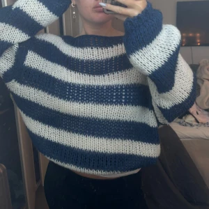 Randig stickad tröja i blått och vitt - Säljer en mysig stickad tröja med breda ränder i blått och vitt. Tröjan har en lös passform och långa ärmar, perfekt för kyliga dagar. Den ger en avslappnad look. Perfekt för höst och vinter!