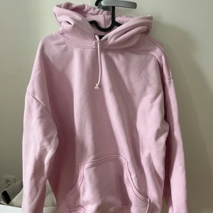 Ljusrosa hoodie från Bik Bok - Säljer en ljusrosa hoodie från Bik Bok i storlek XS. Den har en klassisk design med en stor ficka framtill och justerbar huva med dragsko. Perfekt för en avslappnad stil. 💖