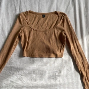 Beige ribbad croppad topp från SHEIN - Säljer en beige ribbad croppad topp från SHEIN.Toppen har långa ärmar och en rundad halsringning. 