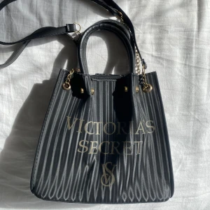 Svart axelväska från Victoria's Secret - Snygg svart axelväska från Victoria's Secret med guldiga detaljer vintage !!!