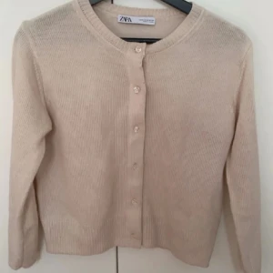 Beige kofta från Zara - Säljer en stilren beige kofta från Zara med rund halsringning och knappar framtill. Passar till både jeans och kjol. Storlek M men passar mig som vanligtvis jag xs-s❤️