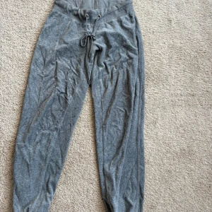 Grå mjukisbyxor med snörning - Säljer ett par grå mjukisbyxor med snörning i midjan. Byxorna har en avslappnad passform och är perfekta för en bekväm dag hemma. De är tillverkade i ett mjukt material som känns skönt mot huden. Kan matchas med koftan jag la ut 