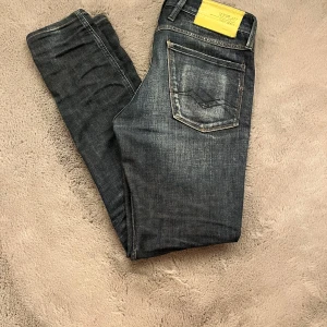 Blå Replay jeans - Snygga blå jeans från Replay. snygga slitningar och en tydlig Replay-logga på baksidan. Perfekta för en avslappnad stil. Storlek W30 L32.            hör av dig vid funderingar!
