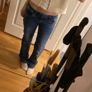Blå jeans från LTB - Snygga blå bootcut jeans från LTB med klassisk femficksdesign och knappgylf. De har en fin passform och är perfekta för en avslappnad stil. 