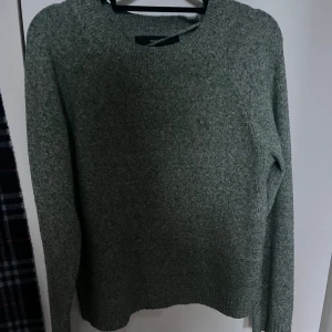 Grön stickad tröja från Vero Moda - Mysig grå stickad tröja från Vero Moda i storlek XS. Tröjan har en klassisk rund halsringning och långa ärmar. Perfekt för lager-på-lager och enkel att matcha med olika outfits.