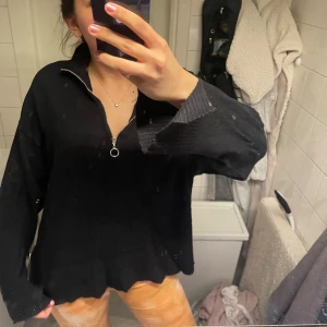 Svart stickad tröja med dragkedja - Svart stickad tröja med halv dragkedja och krage. Tröjan har lång ärm och en avslappnad passform, perfekt för lager-på-lager. Enkel och stilren design som passar till mycket. (Den behövs bara strykas lite men det löser jag om den skulle säljas) 