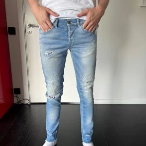 Dondup jeans - Säljer ett par ljusblå skinny jeans med slitningar och hål på knäna från dondup. Passar perfekt till en avslappnad stil och är lätta att matcha med nästan vad som helst. 