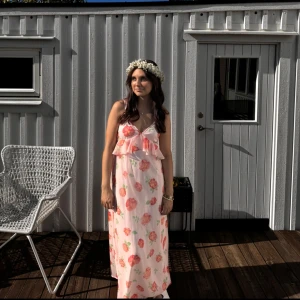 Ljusrosa blommig maxiklänning midsommar  - Superfin långklänning i ljusrosa med stora blommor i rosa. Perfekt till midsommar 