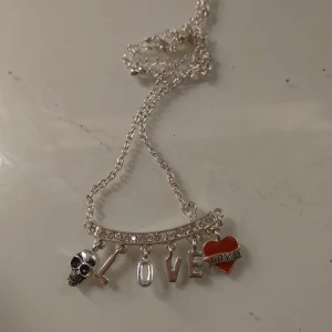 Halsband med döskalle och LOVE-berlock - Halsband med döskalle och love berlock från ur och penn, säljs inte längre. Aldrig används väldigt bra skick. Pris kan diskuteras