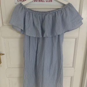 Blåvit offshoulder sommarklänning - Söt blåvit randig klänning med offshoulder och volang upptill. 
