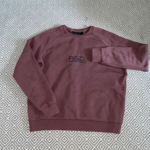 Peak Performance sweatshirt  - Säljer en vinröd sweatshirt från Peak Performance i storlek S. Tröjan har broderad logga framtill och tryck på ryggen med R&D-logga. Klassisk rund hals, ribbade muddar och mjukt bomullsmaterial. Perfekt för en chill och snygg retrolook.