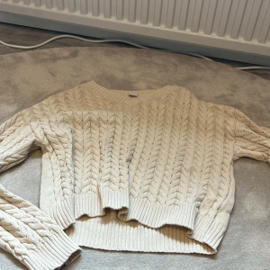 Beige stickad tröja från Lindex - Säljer en beige stickad tröja från Lindex med flätstickat mönster och ribbade muddar. Tröjan har lång ärm och rund halsringning. Perfekt för kyligare dagar och passar till det mesta i garderoben. Hör av dig vid intresse eller frågor❤️