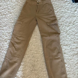 Beiga cargopants från Pull&Bear - Säljer ett par beiga cargopants från Pull&Bear med raka ben och stora fickor på sidorna. Byxorna har normal passform. Obs!köparen står för frakten!❤️