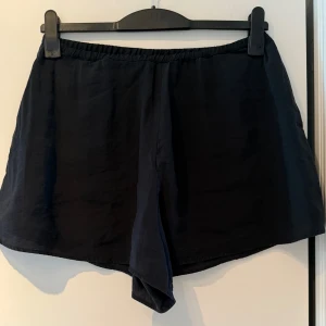 Svarta shorts - Supersköna svarta shorts med elastisk midja, från Zara. En dold ficka på varje sida. Mjuka och ger en lätt och luftig känsla. Passar perfekt för varma dagar och har en klassisk, avslappnad look.
