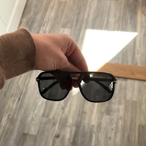 Svarta pilotbågar solglasögon - Stilrena svarta solglasögon med klassisk pilotform och mörka glas. Bågarna har en snygg dubbelbrygga och tunna skalmar. Perfekta för en cool look i solen. Liknar tom ford 