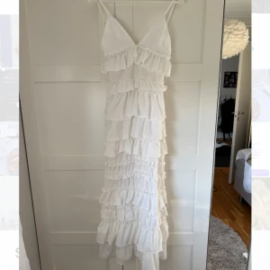 Vit långklänning med volanger - Säljer den underbara vita långklänningen med volanger, perfekt till midsommar, bal eller mottagning. Stl XS.💕💕 använd 1 gång så jättebra skick.