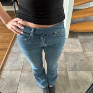 Blå bootcut jeans - Säljer ett par y2k blå bootcut jeans med låg midja.  fina detaljer vid midjan. nypris 500kr använda fåtal gånger. 