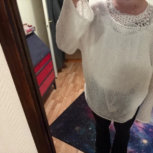 Vit stickad croppad tröja - Säljer en vit stickad croppad tröja med lång ärm. Tröjan har en luftig och grovstickad design som ger en avslappnad och trendig look. Perfekt att styla över ett linne eller topp för en cool lager-på-lager känsla. Hade ingen etikett på men tror jag har beställt denna från SHEIN, har inte använt men är lite uttöjd! Chansar på storlek, men den e för stor för mig och jag har S eller M i storlek.