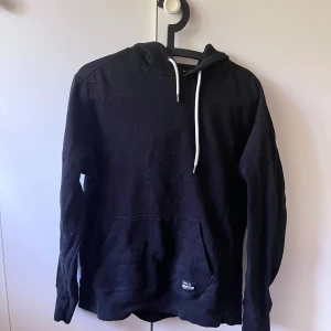 Svart hoodie med vita snören L - Aldrig använd