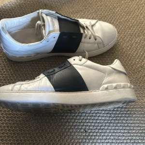 Valentino Garavani vita sneakers med blå band - Säljer ett par vita sneakers från Valentino Garavani, helt okej skick, dom är i storlek 44