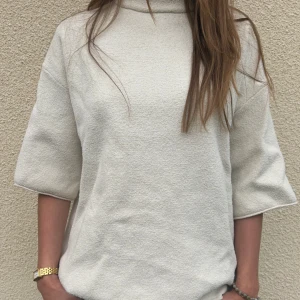 Zara tröja - Säljer en stilren beige polotröja med korta, vida ärmar och lös passform. Tröjan har en hög krage och är tillverkad i ett mjukt, strukturerat material. Perfekt för en avslappnad men trendig look. Säljer då jag inte känner att jag får användning av den!💕