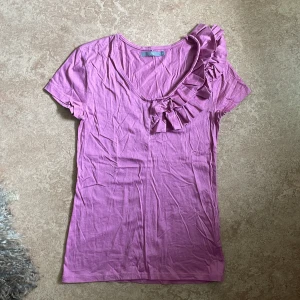 T-shirt med volang detaljer - Säljer en jätte söt t-shirt med volang detaljer. Den är lite skrynklig men i bra skick. Material är 100% bomull. Storlek S. 