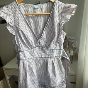 Blus med broderier - Ljuslila/rosa blus med mörkblå ränder, har dragkedja i sidan och knytes i ryggen. Superfin passform💗