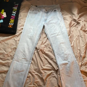 Ljusblå jeansbyxor från Lee - Säljer ett par klassiska ljusblå jeans från Lee med fem fickor och raka ben. Jeansen har normal passform och är tillverkade i ett slitstarkt jeanstyg. Perfekta för dig som gillar en tidlös och enkel stil. Byxorna är mid waist/low waist, jätte fin ljusblå färg på byxorna. 38/40 storlek. Står 33/34 men dom är mindre. Är du 175 eller runt är byxorna perfekt länge för dig! 