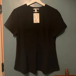 Svart utsvängd topp - En stilren svart topp från H&M som är utsvängd nertill. 