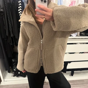 Beige teddyjacka med dragkedja - Mysig beige teddyjacka från HM med hög krage och två stora fickor framtill. Den är använd 3-5 gånger så mycket bra skick! Storlek S men är oversized.🌷