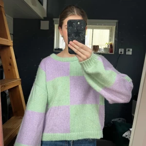 Pastellgrön och lila stickad tröja från Vero Moda - Superfin stickad tröja från Vero Moda i pastellgrönt och lila rutmönster. Perfekt för dig som gillar färg och vill ha en mysig vardagströja! 