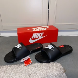 Svarta Nike Victori One Slide tofflor - Helt nya Nike tofflor, schyssta tofflor till sommaren. Strl 41. Nypris 349kr. Skriv för fler bilder eller frågor🙌